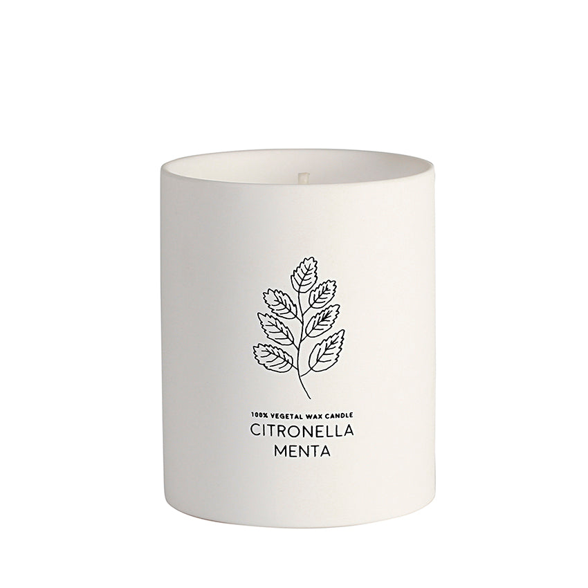 Vela antimosquitos en vaso de cerámica blanca.