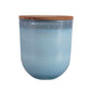 Vela grande en vaso de cristal de color  y tapa de madera con tres mechas.