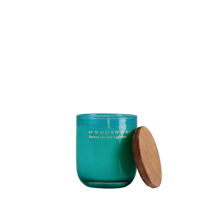 Small candle in a colored glass vase and wooden lid.