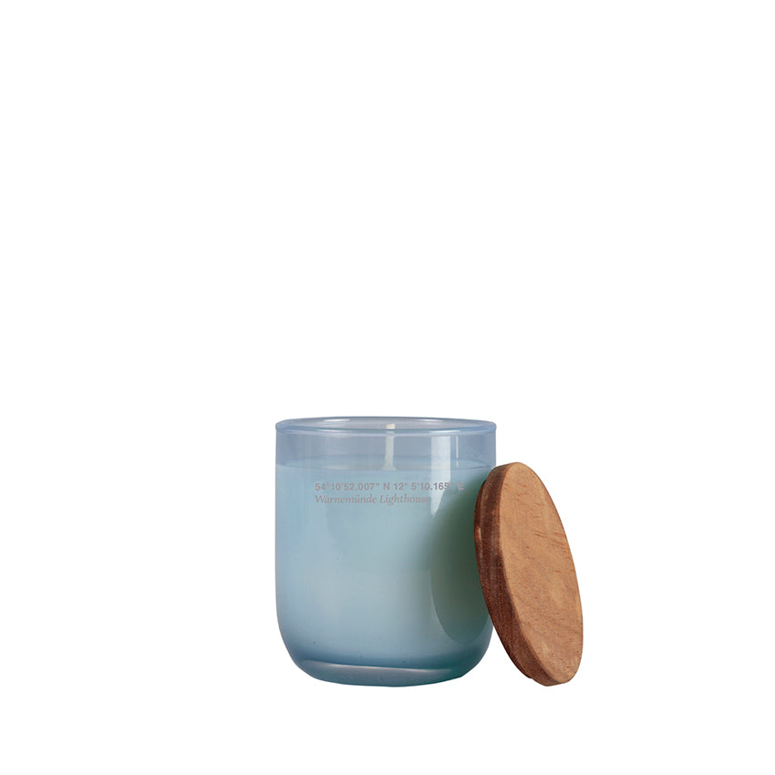 Small candle in a colored glass vase and wooden lid.